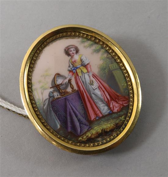 A 9ct gold mounted oval portrait miniature of a lady by a globe, 1.5in.